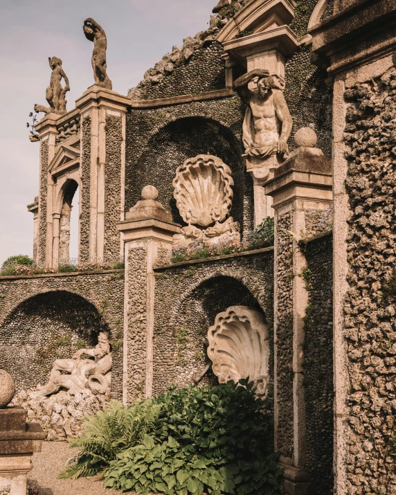 some statues stand in front of a stone structure