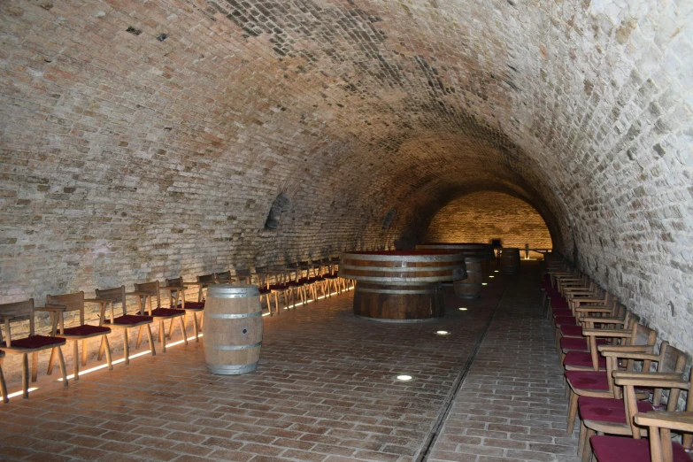 several barrels are on the ground in a dimly lit cellar