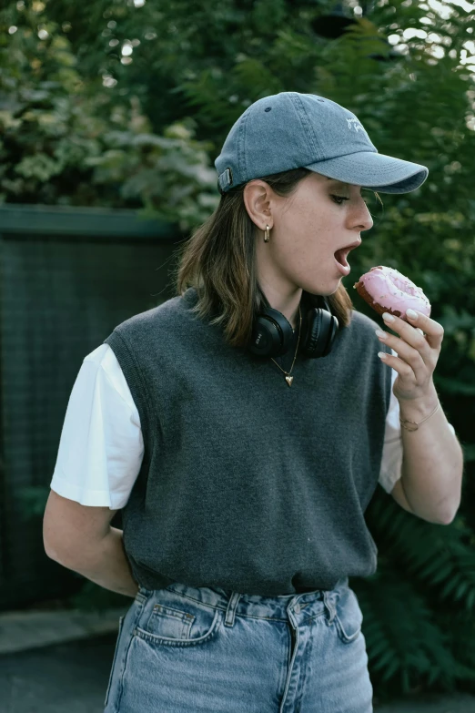 the woman is wearing headphones and eating a donut