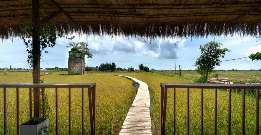 a walkway with an old barn in the background