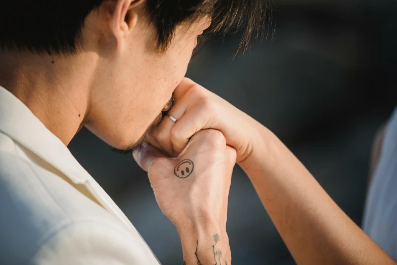 a man wearing a small tattoo on his right wrist