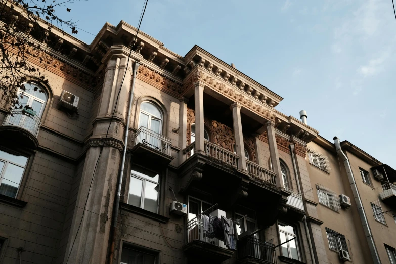 an old brown building with several balconies and clock on it