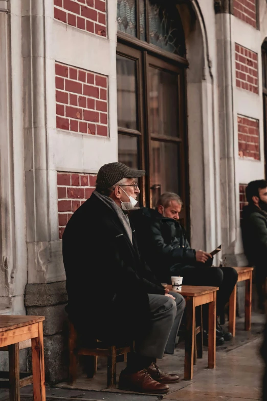 an old man sitting down at a table reading