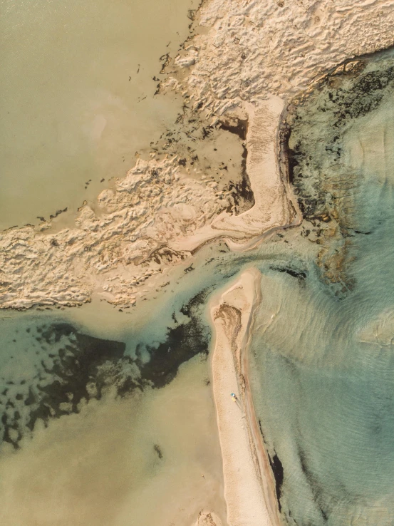 an aerial view of a body of water and sand