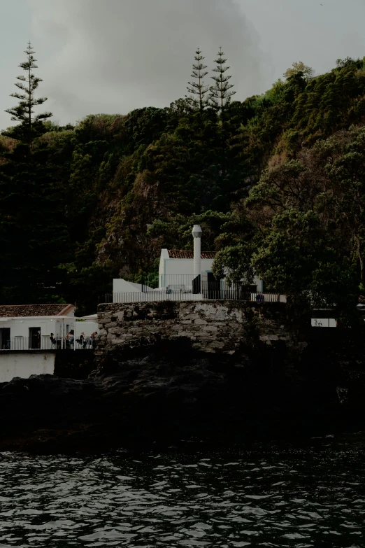 a boat is parked near the shore with a house by the water