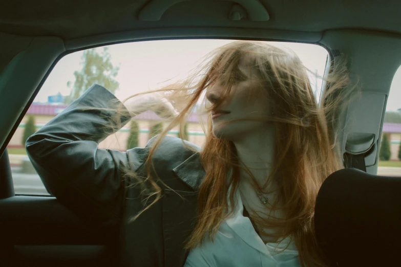 an attractive woman standing in the front seat of a car