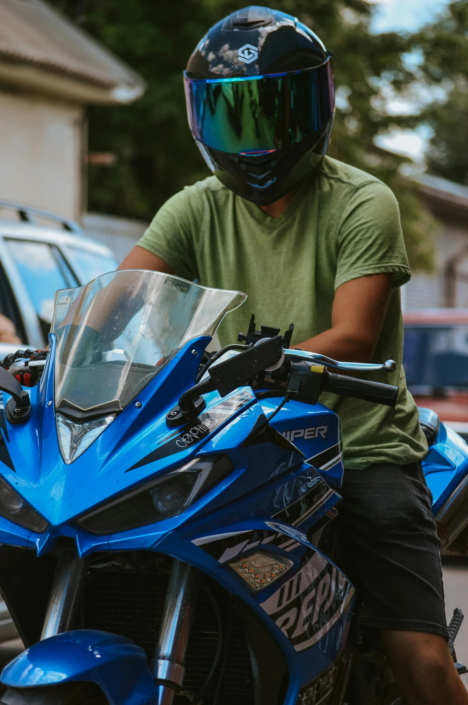a man wearing a motorcycle helmet sits on a blue sportsbike