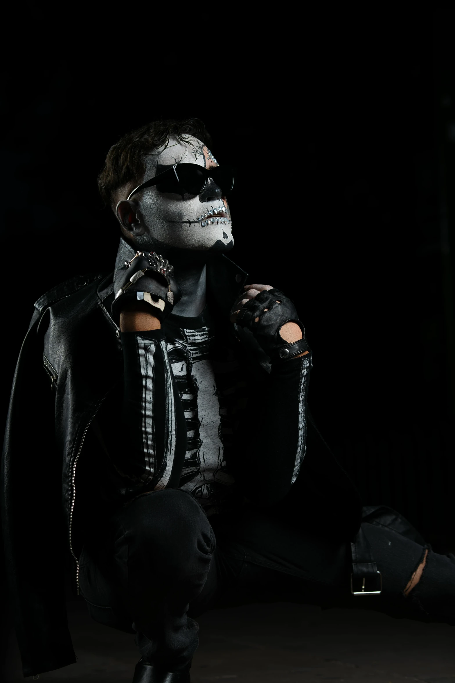 a man in leather and white paint is dressed in a full mask