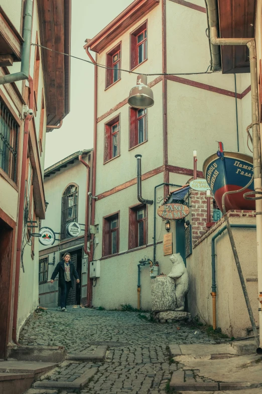 two people are walking down the narrow street