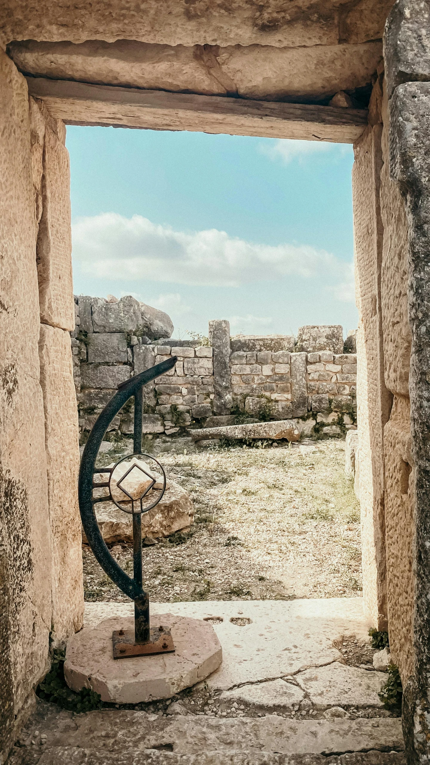 a black iron sculpture in an ancient doorway