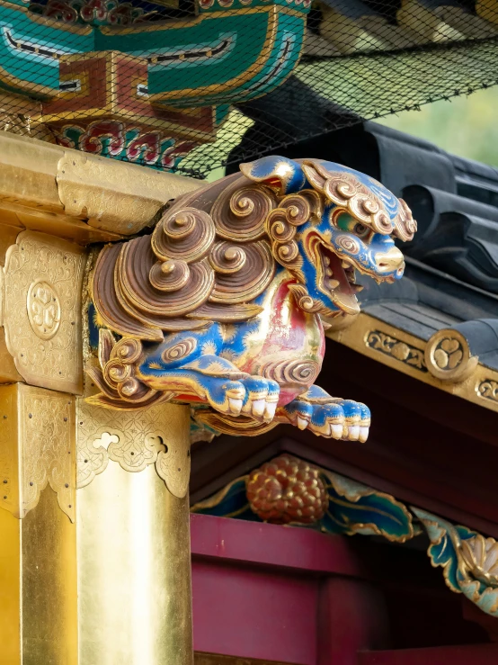 a decorative golden gargon on the side of a building