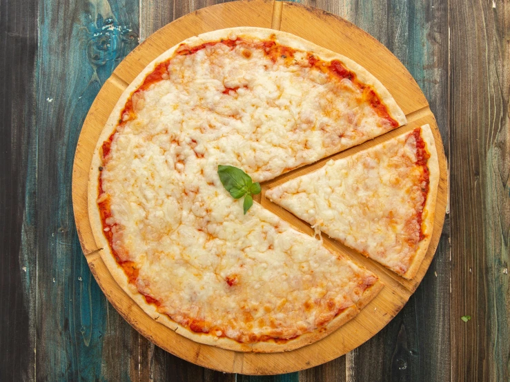 a pizza cut into four pieces sitting on top of a  board