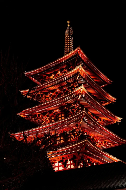 an oriental style building in front of a dark sky