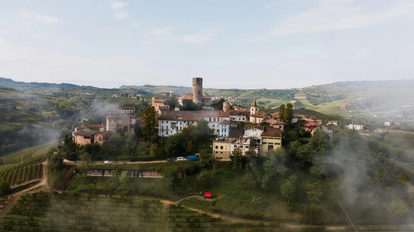 an aerial view of a village with a tower on top of a hill