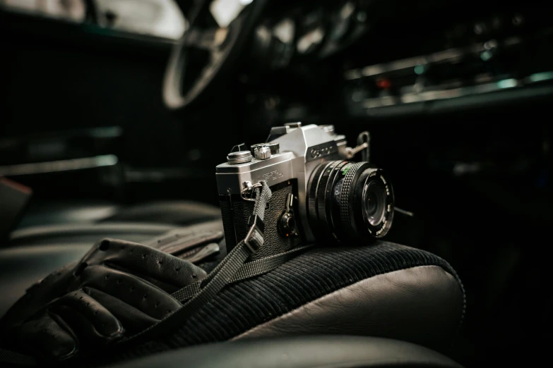 a camera sitting on top of a leather seat next to a steering wheel