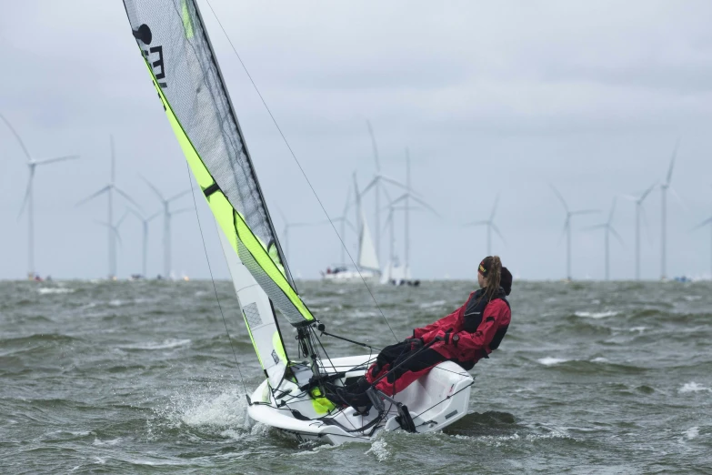 a man riding on the back of a sailboat in the ocean