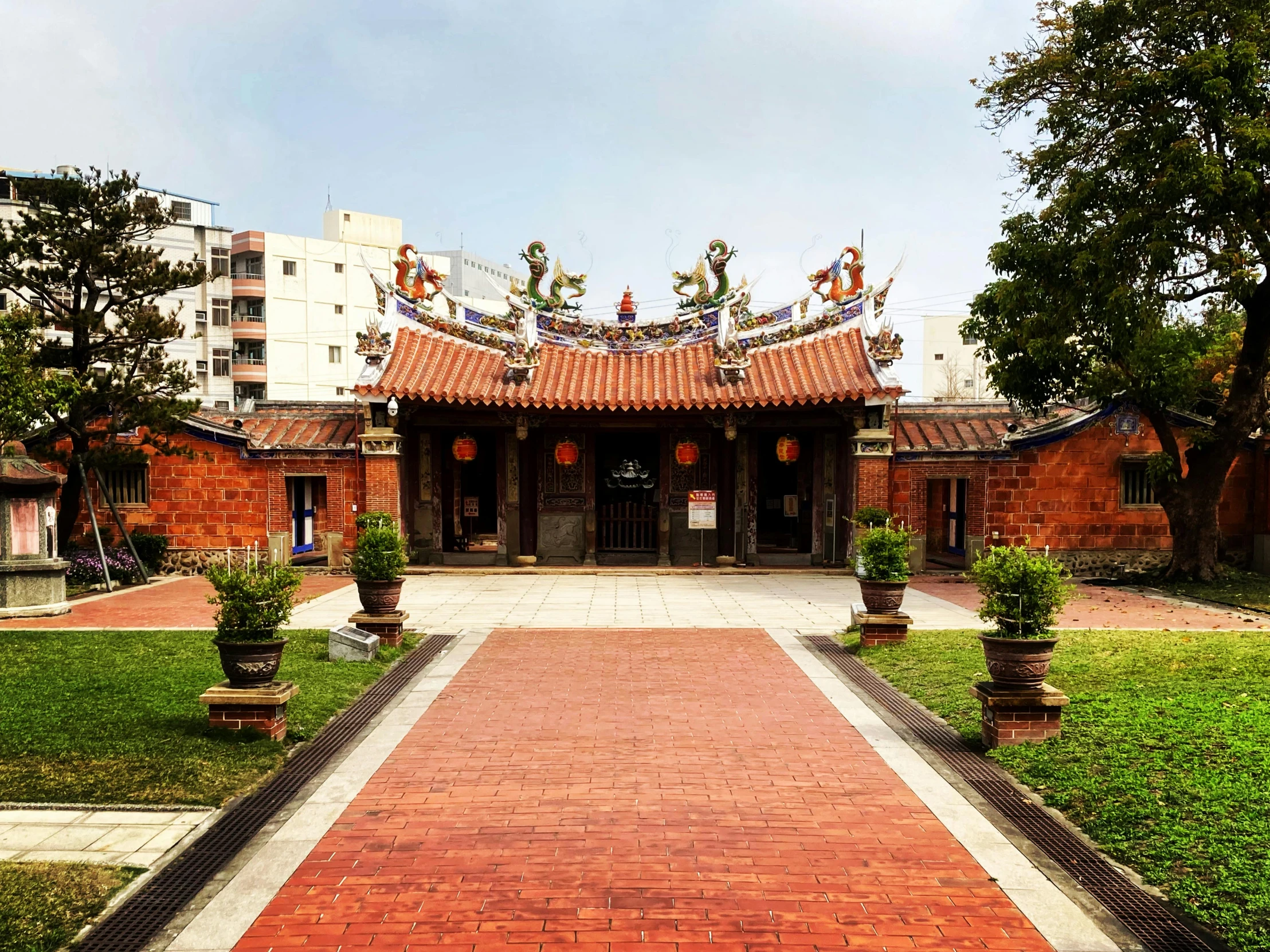 an old red brick building with statues around it