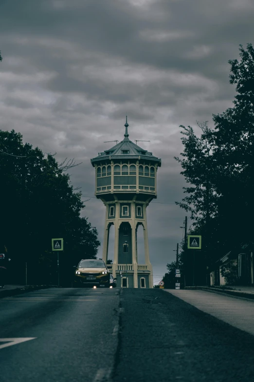 a very tall clock tower sitting over a street