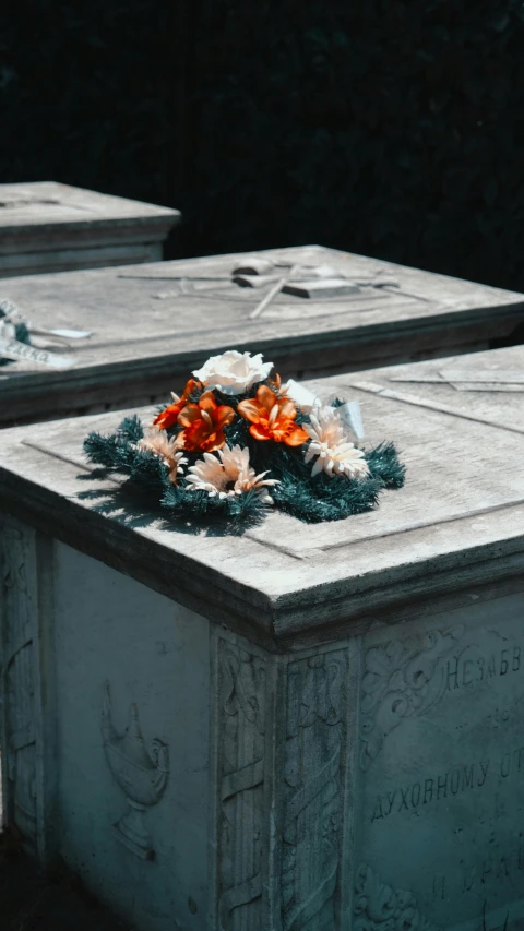 the headstones of some concrete monuments have flowers in them