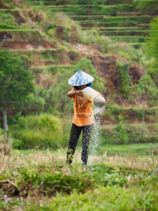 a woman wearing an umbrella and carrying soing out of the water