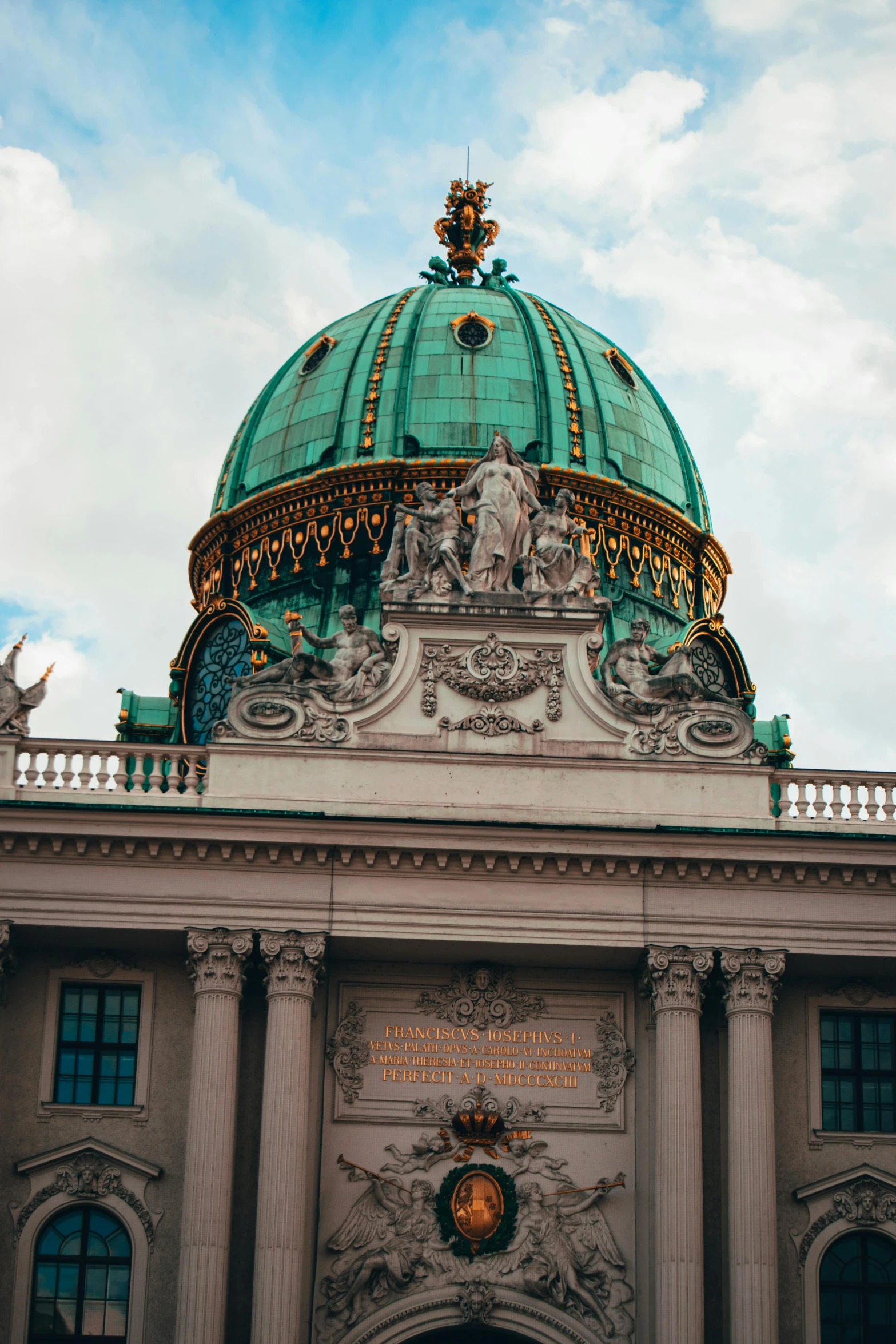 the top of an ornate building with columns and arches under a blue sky