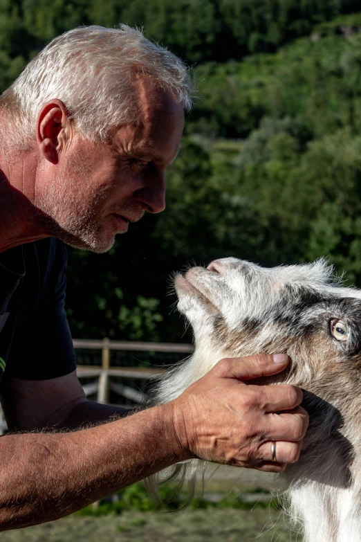 the man is feeding the dog with his hand