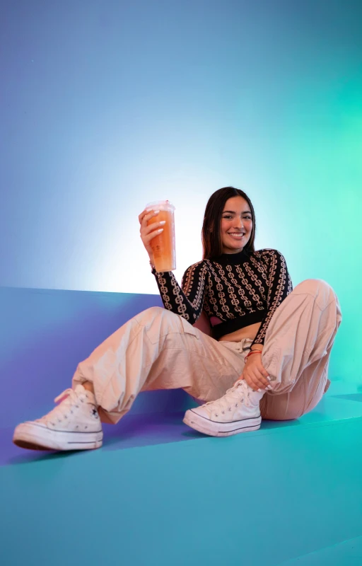 a woman with long hair smiling while holding a glass