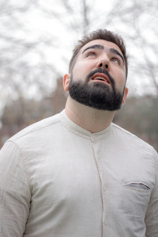 a close - up po of a bearded man looking up