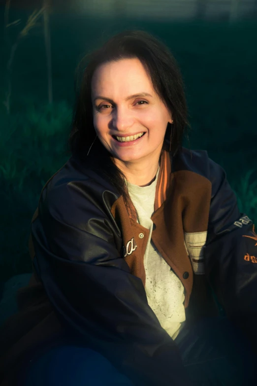 an attractive woman wearing a jacket while smiling