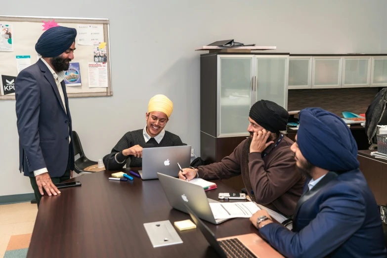 a group of people working on their laptops