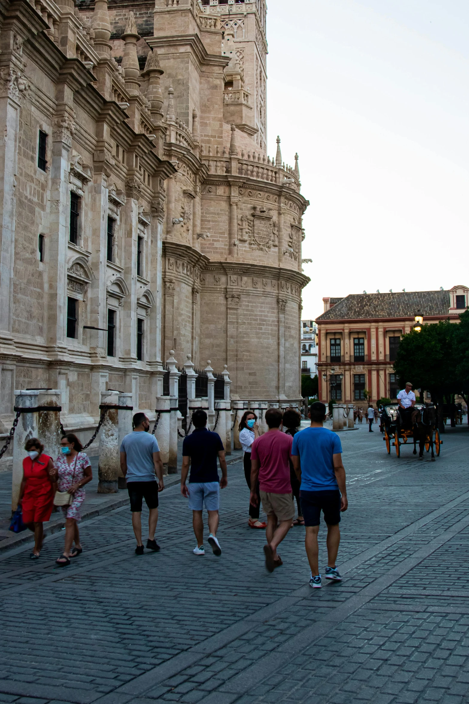 people are walking along a brick walkway near a castle