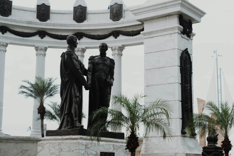 the statues of three people in front of a white archway
