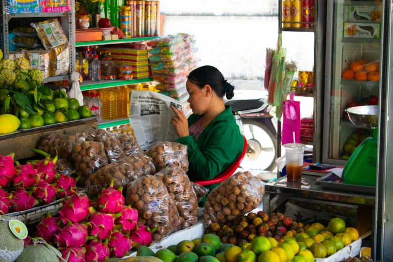 a woman reading a book next to various fresh fruits