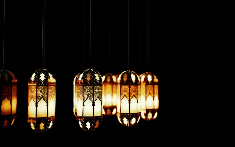 three hanging lamps in the dark above them