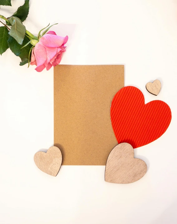 red and brown paper hearts with one rose on white