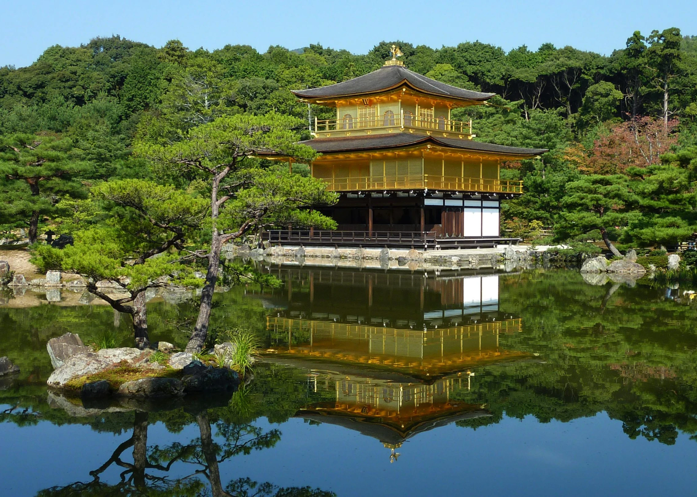 a tall, golden building surrounded by a body of water