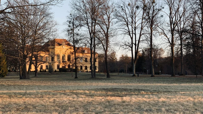 an old, stone and stone building is shown from the across a park