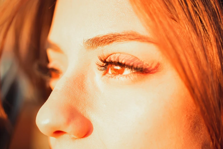 close up of female eye with orange and yellow makeup