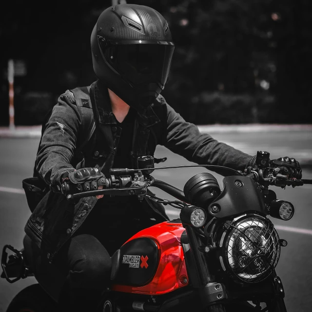 a man wearing a helmet and holding the seat of his motorcycle