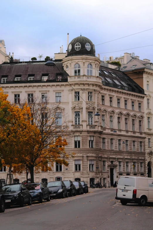 a building with a tower is next to parked cars