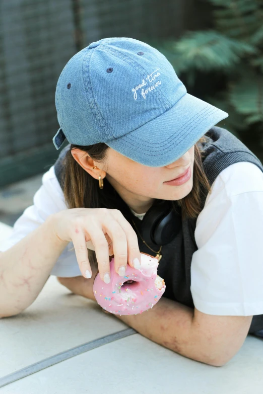 a woman sitting on the ground holding a doughnut