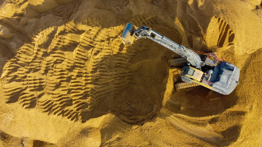 a crane digging through the sand in an open field