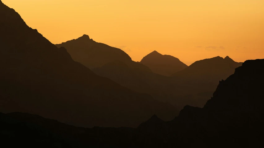 a landscape po at sunset, of mountains that are silhouetted by the sky