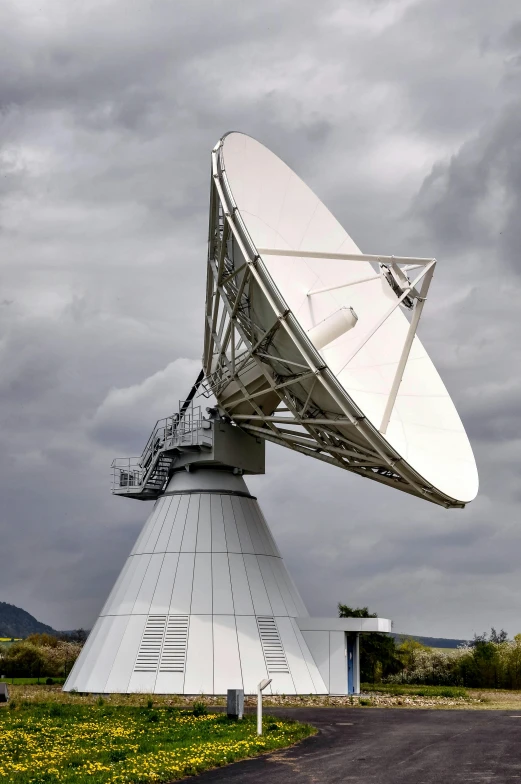 a white satellite dish with some other equipment in the background