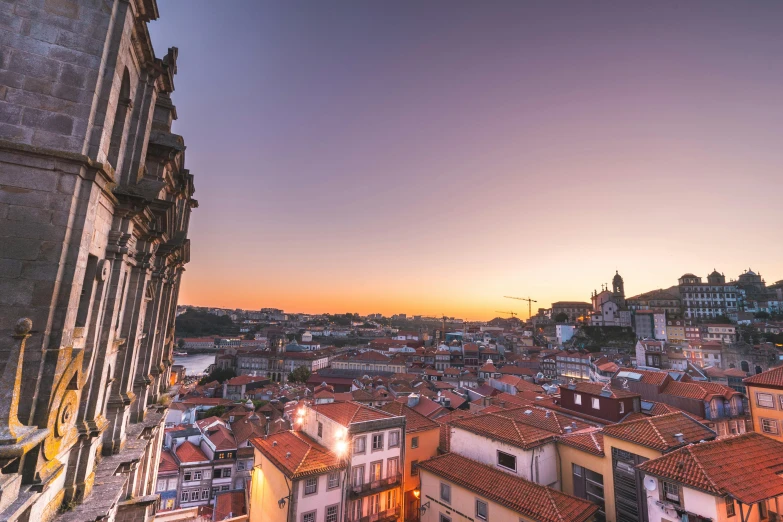 a cityscape with a clock tower at sunset