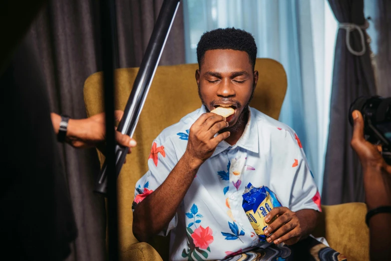 a man eating food from a container while filming someone