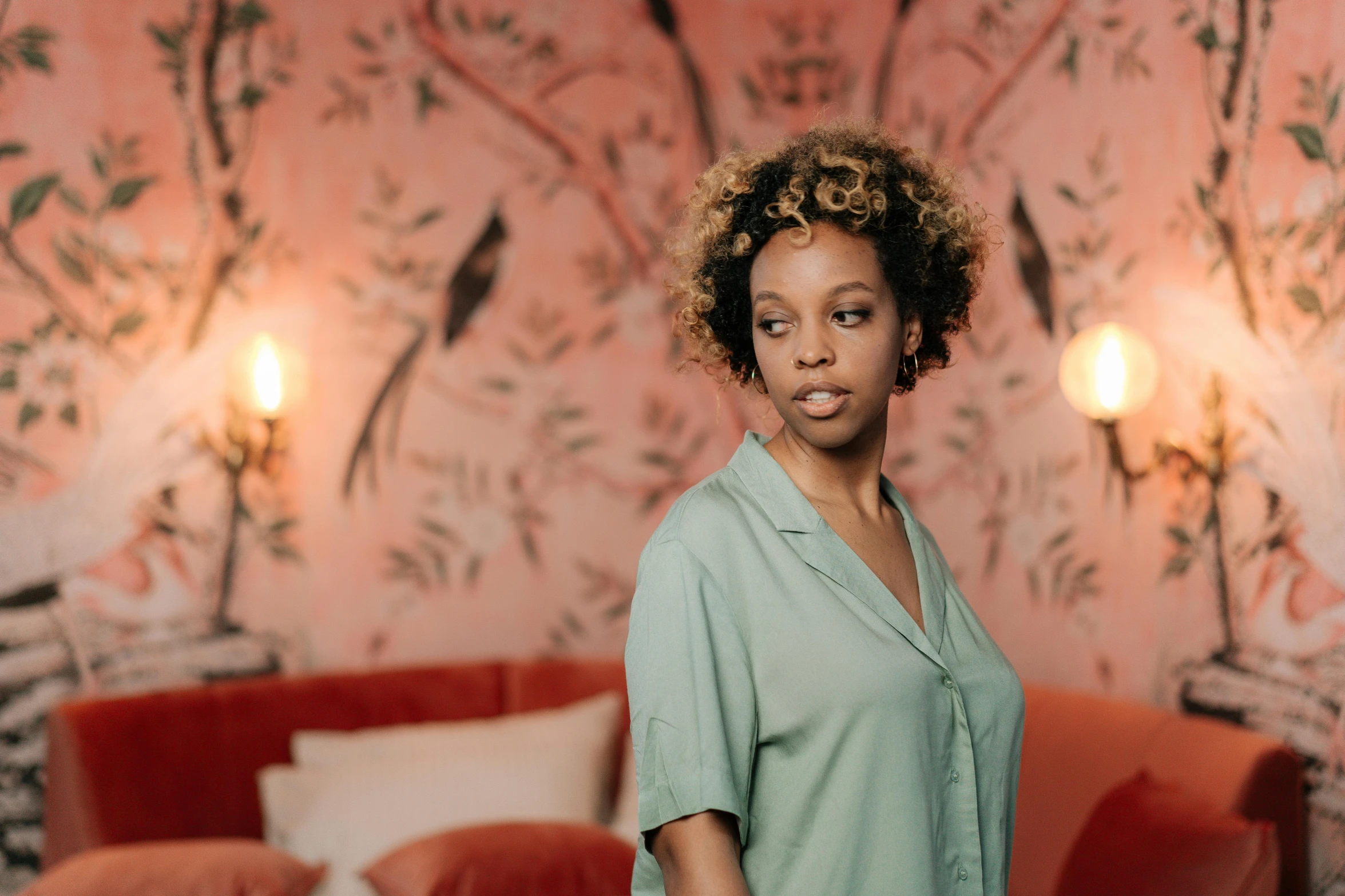 an african american woman standing in a pink floral room