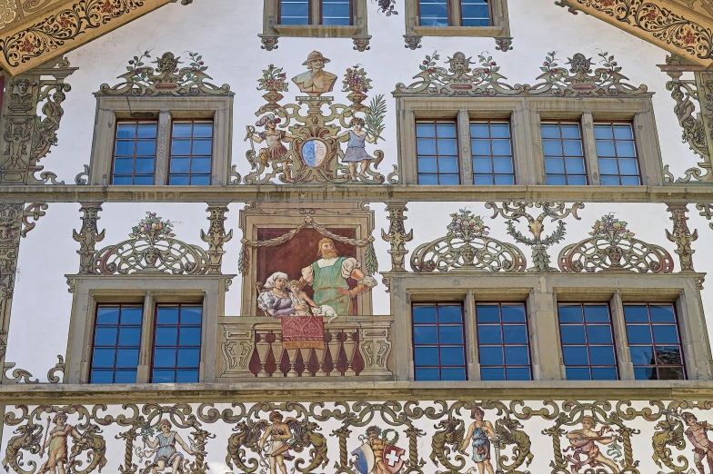 an ornate building that has painted artwork on the sides of it