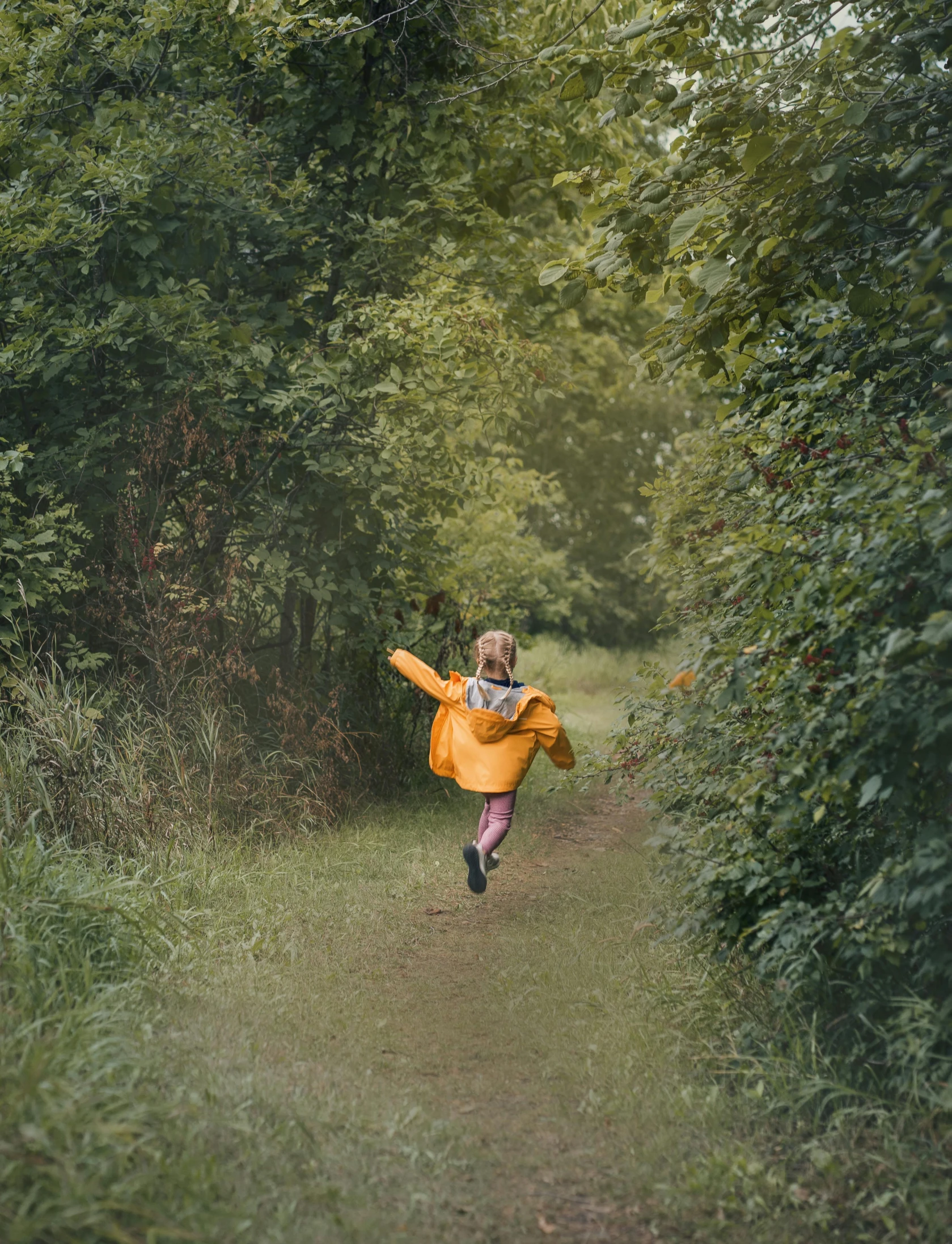 a woman in yellow running through the forest