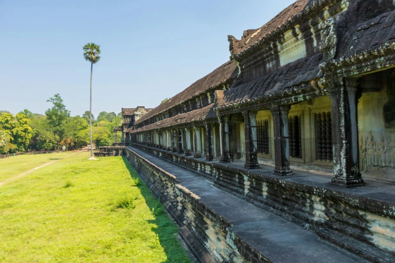 an old building sitting in the middle of a lush green field